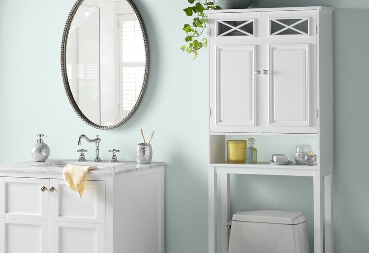 светло-мятная ванная комната с белой мебелью и овальным зеркалом