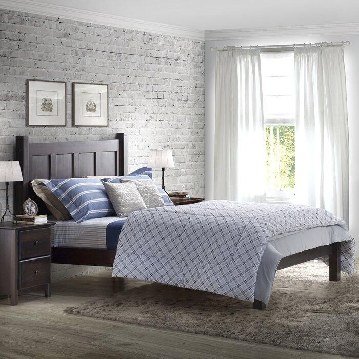 белая спальня с кирпичной стеной и темной деревянной мебелью.jpeg