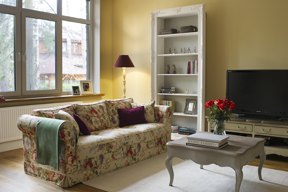 гостиная с диваном с цветочным принтом и белой мебелью