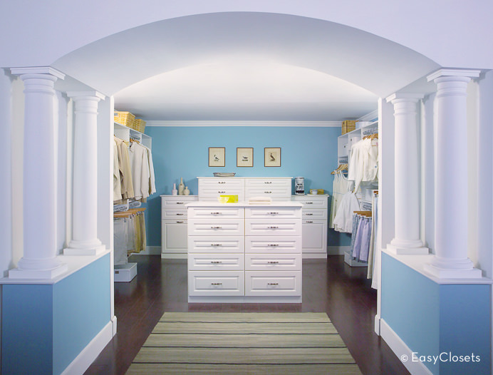большая гардеробная комната с голубыми стенами и белой мебелью и колоннами.jpg