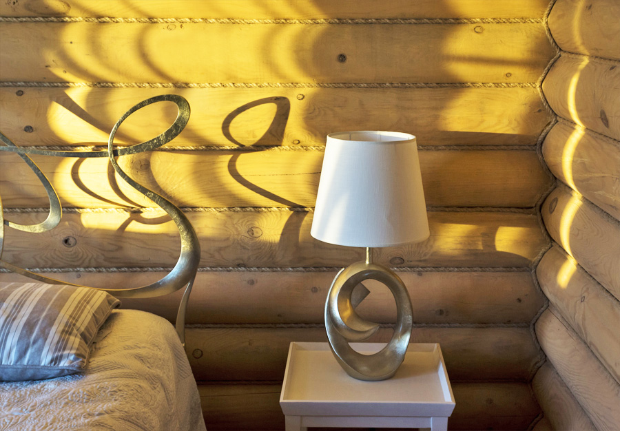 настольная лампа на прикроватной тумбе в деревянном доме