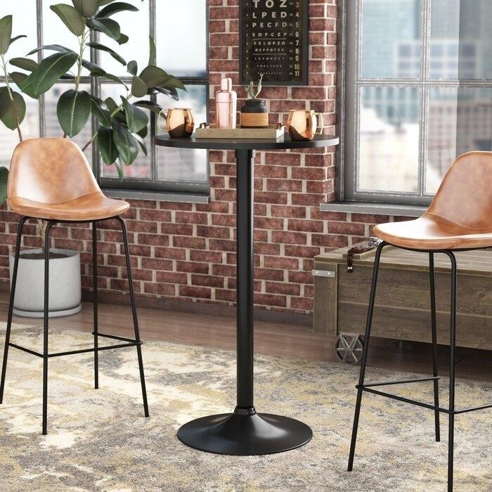 высокий черный металлический круглый барный стол с двумя стульями на металлических ножках со светло-коричневым кожанным сидением.jpeg